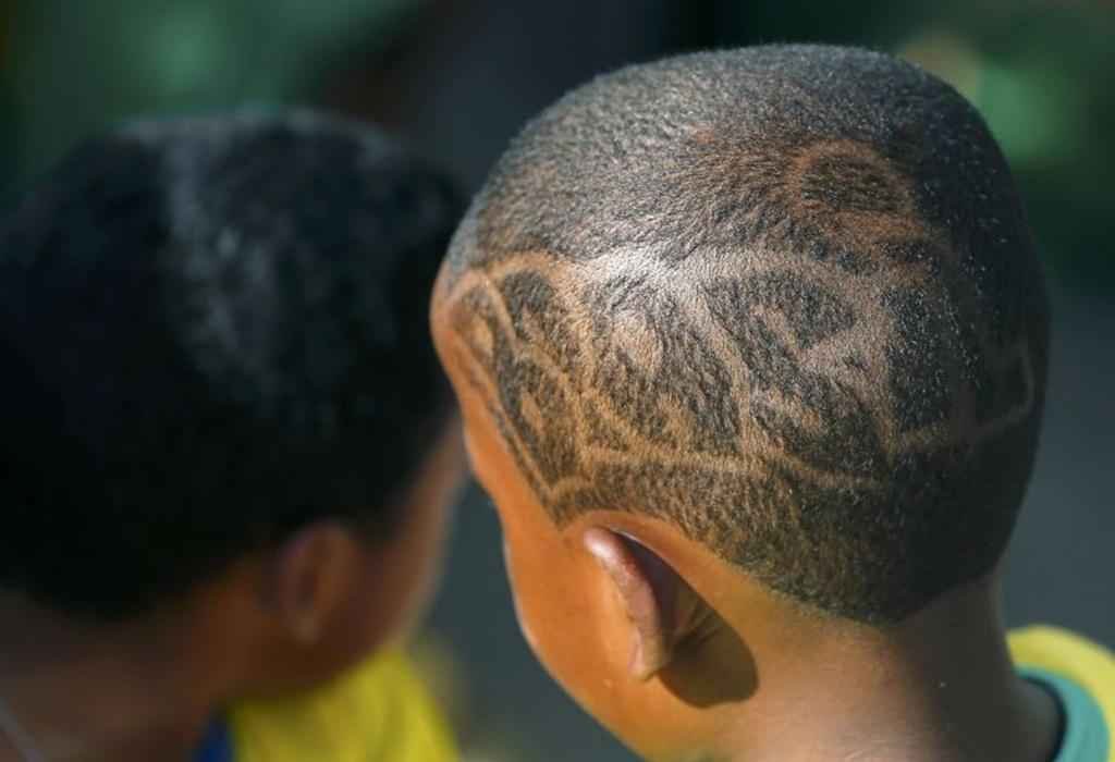 Garoto estiliza o cabelo com  o nome do Brasil. Recife (PE).
