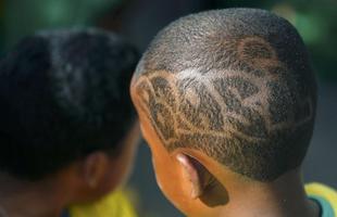 Garoto estiliza o cabelo com  o nome do Brasil. Recife (PE).